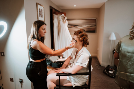 Corinne doing makeup on bride